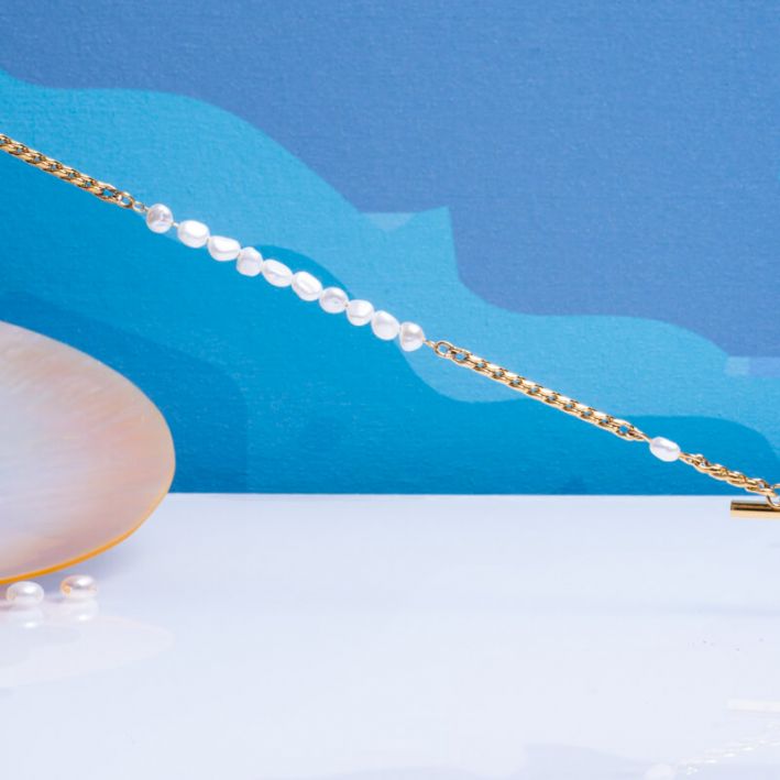 Bracelet mailles tendance en acier doré et perles de culture rondes baroques blanches 