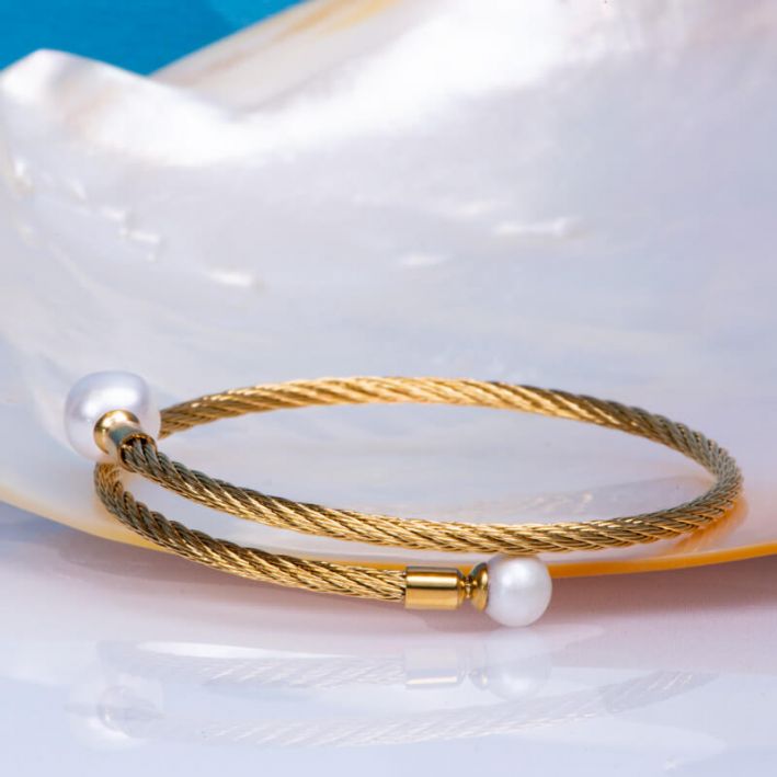 Bracelet jonc en acier doré et ses deux perles de culture blanches