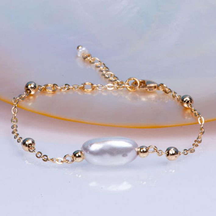 Bracelet chaîne acier doré et sa perle de culture blanche en forme de coquillage