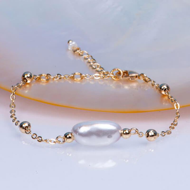 Bracelet chaîne acier doré et sa perle de culture blanche en forme de coquillage