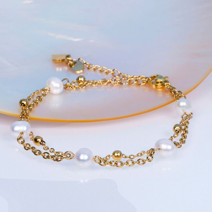 Bracelet double rangs de chaînes en acier doré et perles de culture blanches
