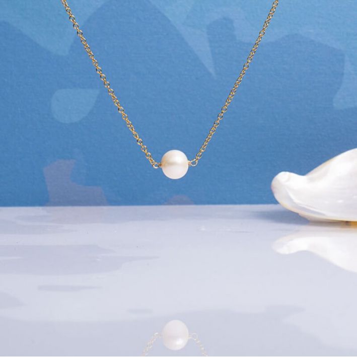 Collier une perle de culture ronde et blanche sur chaîne dorée