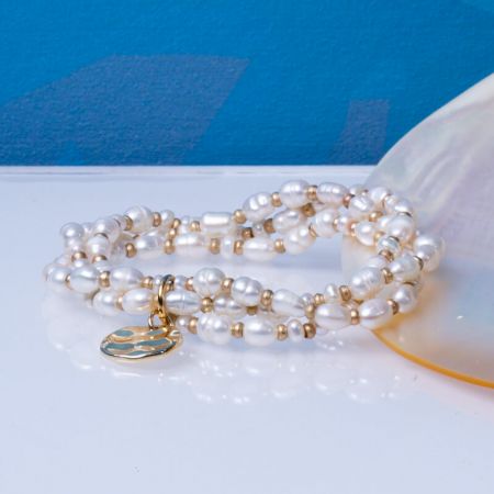 Bracelet perles de culture blanches et sa médaille martelée dorée