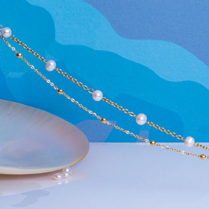 Bracelet double rangs de chaînes en acier doré et perles de culture blanches